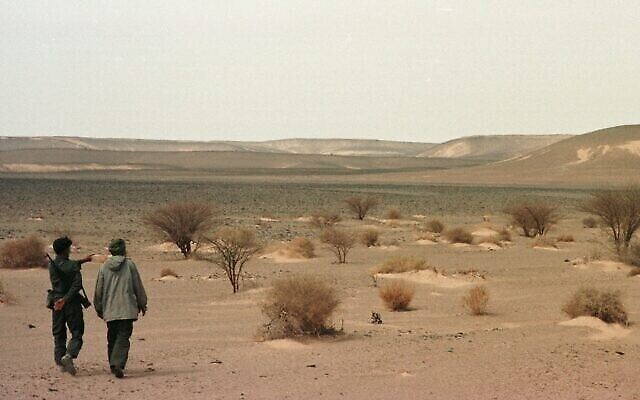 Deux soldats rebelles du Front Polisario désignent les positions de l'armée marocaine, tout en patrouillant une ligne de cessez-le-feu dans le nord du Sahara occidental, à 65 km au nord de la ville de Tifariti, le 26 septembre 1997. (AP Photo/Armando Franca)