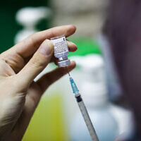 Une infirmière israélienne prépare un vaccin COVID-19 dans un centre de vaccination à Jérusalem, le 23 décembre 2020. (Crédit : Olivier Fitoussi/Flash90)