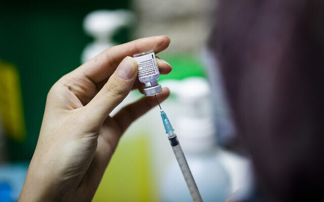 Une infirmière israélienne prépare un vaccin COVID-19 dans un centre de vaccination à Jérusalem, le 23 décembre 2020. (Crédit : Olivier Fitoussi/Flash90)