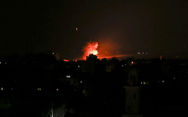 De la fumée et des flammes suite à une frappe aérienne israélienne à Gaza City, après le lancement par les terroristes de roquettes en Israël, le 26 décembre 2020. (Crédit : Mahmud Hams/AFP)