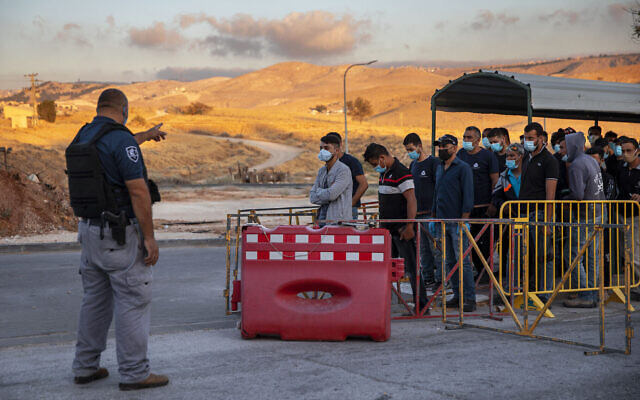 Illustration : des travailleurs palestiniens font la queue pour franchir un point de contrôle à l'entrée de Cisjordanie de Maale Adumim, près de Jérusalem, le 30 juin 2020. (Crédit : AP Photo/Oded Balilty, Archive)