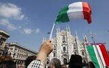 Un homme brandit un drapeau italien devant la cathédrale gothique de Milan, en Italie, à l'occasion de la Journée de la libération, le dimanche 25 avril 2010. (Crédit ; AP Photo/Luca Bruno)