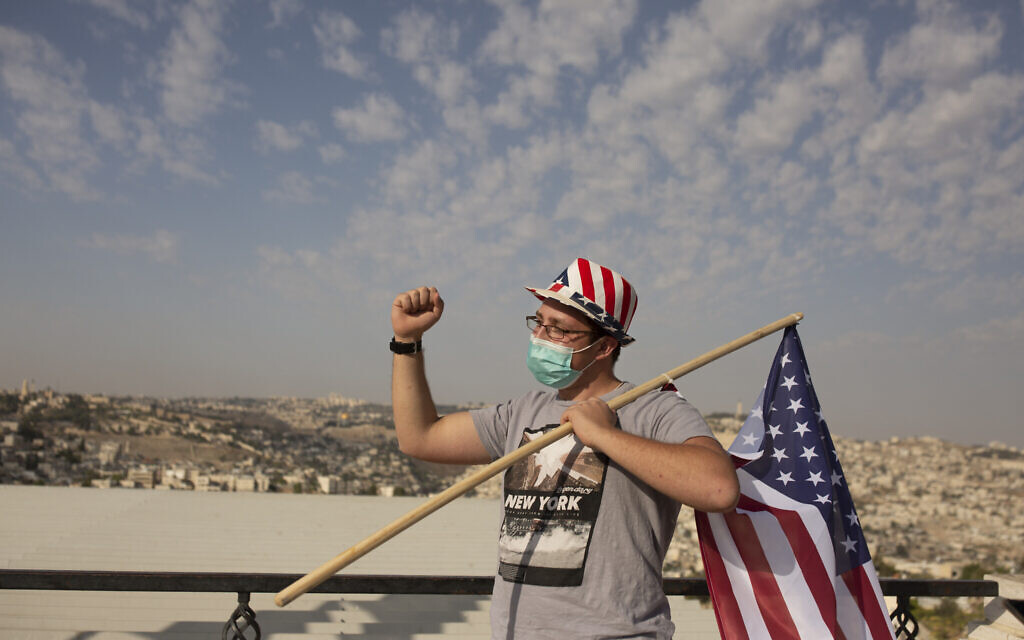 Un supporter israélien du président américain Donald Trump porte un chapeau aux couleurs du drapeau américain lors d'un rassemblement pour sa réélection, sur une promenade surplombant Jérusalem, le 27 octobre 2020. (Crédit : AP Photo/Maya Alleruzzo)