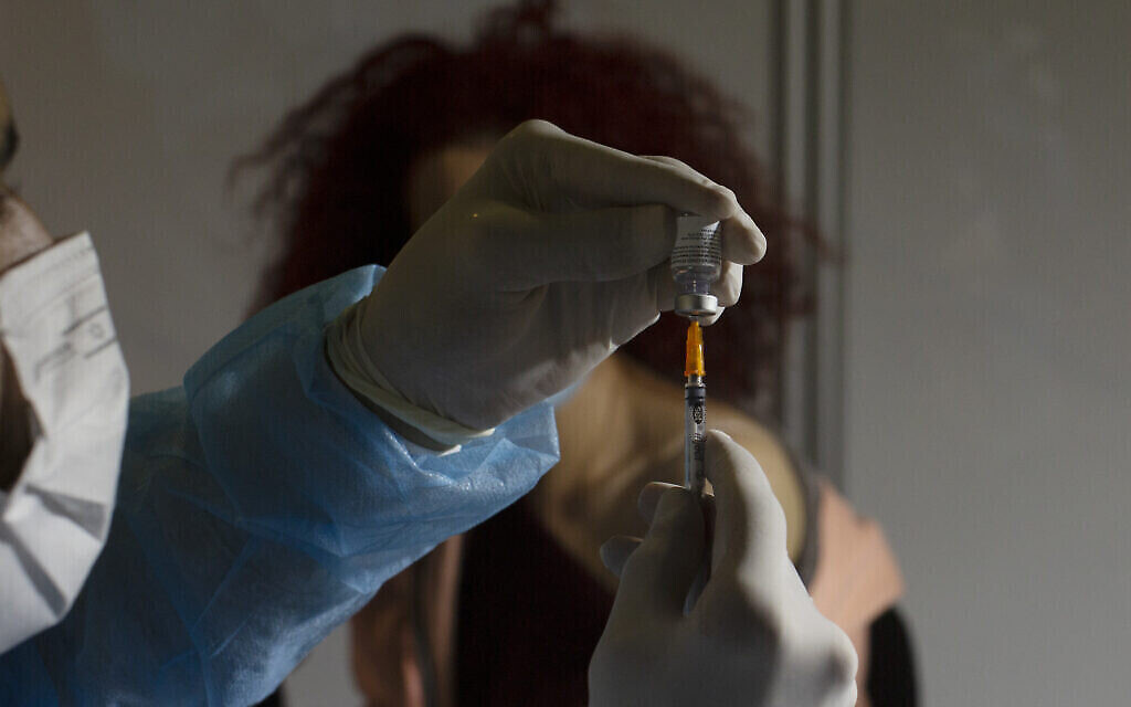 Un professionnel de la santé prépare une dose du vaccin COVID-19 de Pfizer dans un centre de vaccination provisoire dans un stade de Jérusalem, le 14 janvier 2021. (AP Photo / Maya Alleruzzo)
