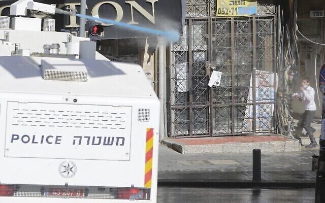 La police israélienne utilise un canon à eau pendant les affrontements survenus en raison de l'ouverture des écoles dans un quartier ultra-orthodoxe de Jérusalem, le 24 janvier 2021. (Crédit : AP Photo/Sebastian Scheiner)