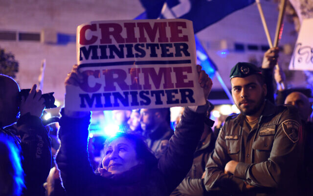 Une femme israélienne brandit une pancarte alors que des manifestants de gauche et de droite sont séparés par la police lors des manifestations de soutien et de protestation contre le Premier ministre Benjamin Netanyahu à Tel Aviv, le 2 mars 2019. (Gili Yaari/Flash90)