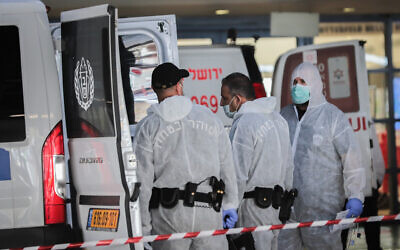 Gardes de prison portant des vêtements de protection à titre préventif contre le coronavirus, vus lors du transport d'un prisonnier suspecté d'être atteint du coronavirus au centre médical Shaare Zedek à Jérusalem, le 30 mars 2020. (Yossi Zamir/Flash90)