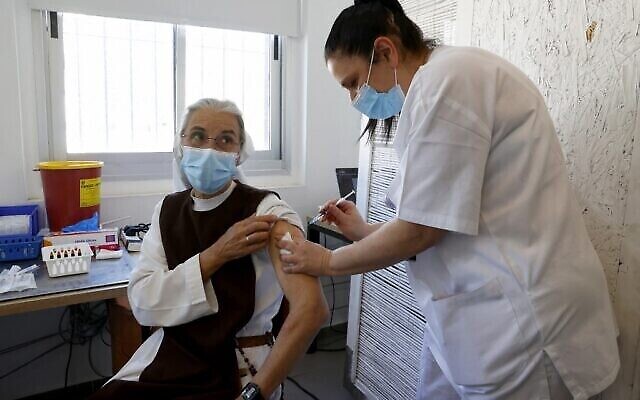 Une religieuse française vivant en Israël se fait vacciner contre la  COVID-19 au centre médical Sourasky de Tel Aviv pendant une campagne de vaccination des ressortissants et des réfugiés étrangers , le 9 février 2021. (Crédit :  JACK GUEZ / AFP)