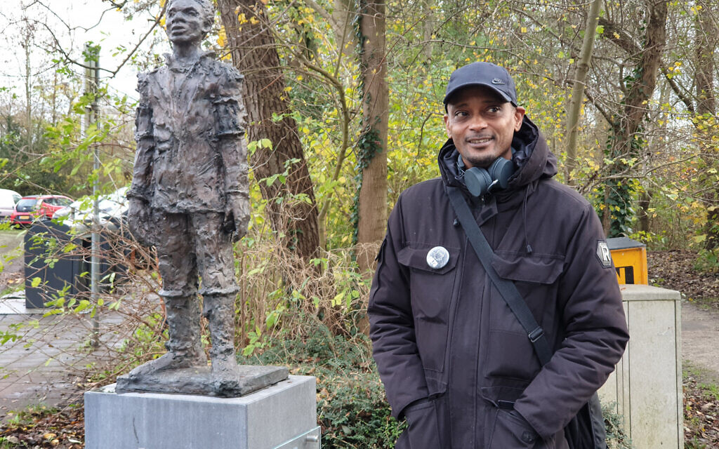 Sergio Berrenstein près de la statue d'Elieser à l'entrée du cimetière juif d'Ouderkerk aan de Amstel, aux Pays-Bas, le 20 novembre 2020. (Crédit : Cnaan Liphshiz/ JTA)