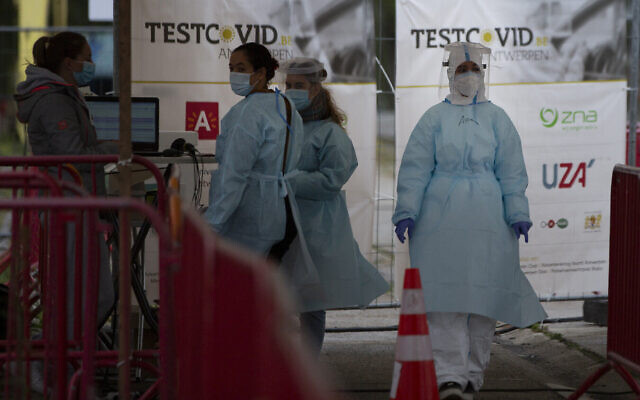 Des employés du secteur de la santé attendent pour faire passer des tests de dépistage rhinopharyngés dans une unité de tests au coronavirus mobile de la ville d'Anvers, en Belgique, le 20 octobre 2020. (Crédit : AP Photo/Virginia Mayo)