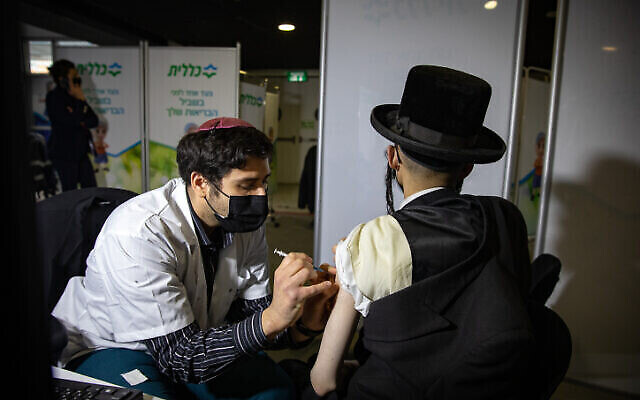 Un Haredi se fait vacciner contre la COVID-19 dans un centre de vaccination Clalit de Jérusalem, le 28 janvier 2021. (Crédit : Olivier Fitoussi/Flash90)
