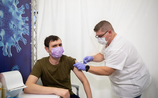 Un homme se fait vacciner contre la COVID-19 dans un centre de vaccination de Holon, le 4 février 2021. (Crédit : Chen Leopold/Flash90)
