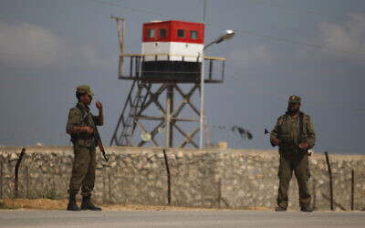 Des gardes palestiniens du Hamas se tiennent près d'une tour de guet égyptienne à la frontière avec l'Égypte à Rafah, dans le sud de la bande de Gaza. (Crédit : AP/Hatem Moussa)