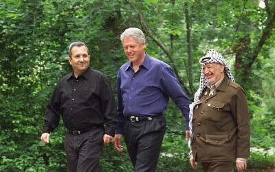 Le président américain de l'époque, Bill Clinton, (au centre), le Premier ministre Ehud Barak (à gauche) et le leader palestinien Yasser Arafat marchent sur le site de Camp David, dans le Maryland, au début du sommet sur le Moyen-Orient, le 11 juillet 2000. (AP Photo/ Ron Edmonds, File)