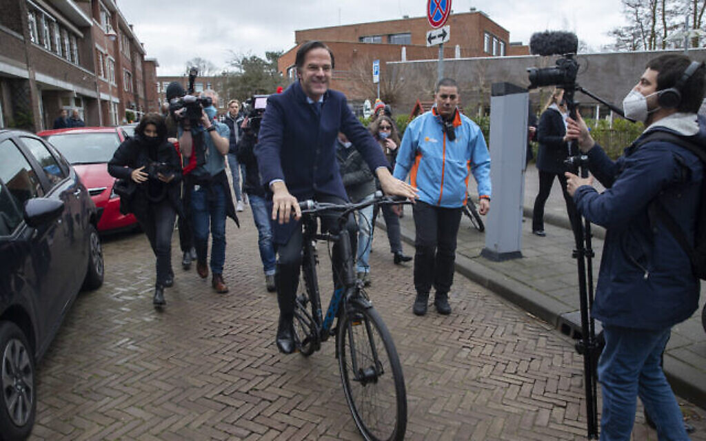 Le Premier ministre du gouvernement transitoire Mark Rutte part en vélo après avoir voté lors des élections générales à La Haye, le 17 mars 2021. (Crédit :  AP Photo/Peter Dejong)