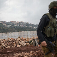 Un soldat israélien marche près de la clôture de la frontière avec le Liban, près de la ville de Metula, au nord d'Israël, le 24 décembre 2018. (Crédit :Hadas Parush/Flash90)