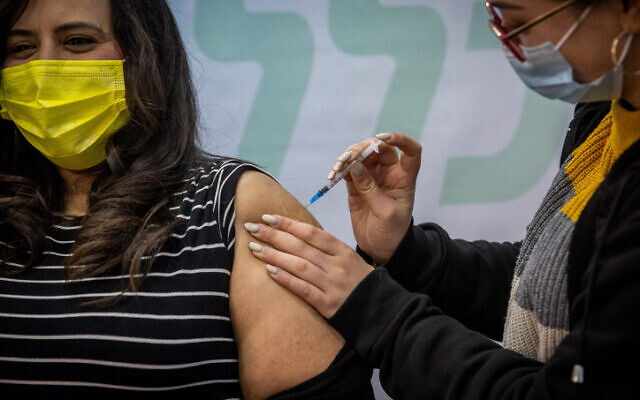 Une Israélienne se fait vacciner à Jérusalem, le 15 février 2021. (Crédit : Yonatan Sindel/Flash90)