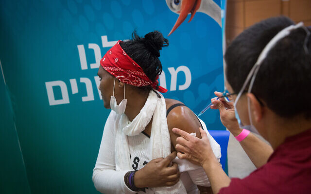 Une Israélienne se fait vacciner contre la COVID-19 dans un centre de vaccination Leumit à Tel Aviv, le 8 mars 2021. (Crédit : Miriam Alster/Flash90)