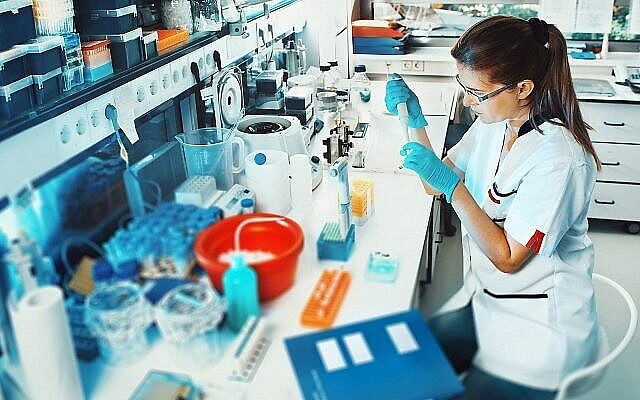 Illustration : une femme travaille dans un laboratoire. (Crédit : Anyaivanova ; iStock by Getty Images)