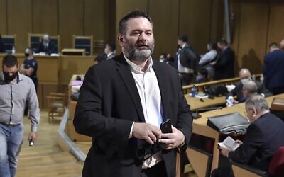 Le député européen indépendant Ioannis Lagos, l'un des principaux dirigeants de l’organisation Aube dorée, qui a fait défection du parti en 2019, après avoir remporté un siège au Parlement européen, quitte la salle d'audience d'Athènes, le 12 octobre 2020. (Crédit : LOUISA GOULIAMAKI / AFP)