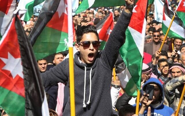Des manifestants jordaniens agitant des drapeaux nationaux et scandant des slogans, appelant à fermer l'ambassade, à expulser l'ambassadeur et à annuler le traité de paix de 1994 avec Israël lors d'une manifestation près de l'ambassade d'Israël, dans la capitale Amman, le 28 juillet 2017. (Crédit : Khalil Mazraawi/AFP)