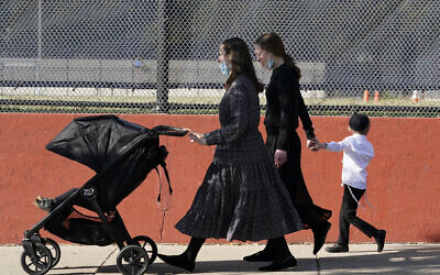 Deux femmes marchent avec des enfants pendant la fête juive de Souccot dans le quartier de Borough Park, dans l'arrondissement de Brooklyn à New York, le 4 octobre 2020. (Crédit : Kathy Willens /AP)