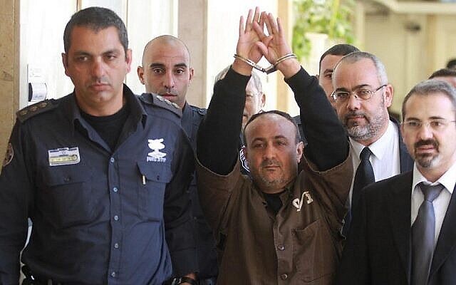 Le dirigeant palestinien du Fatah Marwan Barghouti est escorté par la police israélienne vers le tribunal de première instance de Jérusalem pour témoigner dans le cadre d'un procès civil américain contre les dirigeants palestiniens, en janvier 2012. (Crédit : Flash90)