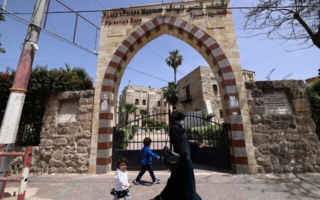 Une femme et un enfant passent devant Qasr al-Basha dans la ville de Gaza, le 21 avril 2021, où Napoléon Bonaparte a dormi plusieurs nuits pendant sa campagne en Égypte et au Levant. (Crédit : Emmanuel DUNAND / AFP)