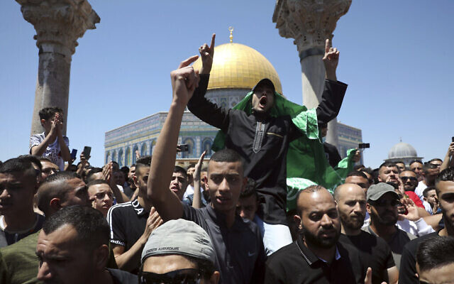 Un fidèle musulman arbore un drapeau du Hamas lors d'une manifestation contre Israël après les prières du vendredi, près du Dôme du Rocher, mosquée dans l'enceinte de la mosquée Al-Aqsa sur le mont du Temple dans la Vieille Ville de Jérusalem, le vendredi 14 mai 2021. (AP Photo / Mahmoud Illean)