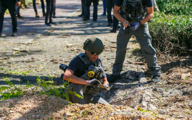 Les forces de sécurité sur les lieux où un fragment d'une roquette tirée depuis la bande de Gaza a atterri dans la ville méridionale d'Ashdod, le 19 mai 2021 (Flash90)