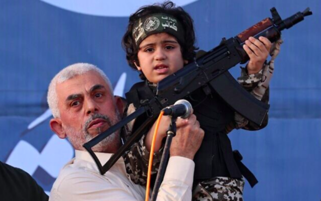 Le chef du Hamas, Yahya Sinwar, tient l'enfant d'un membre des Brigades Ezzedin  Al-Qassam, tué lors des récents combats avec Israël, le 24 mai 2021. (Crédit : Emmanuel Dunand/AFP)