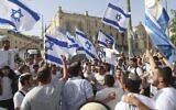 Des Israéliens brandissent des drapeaux lors d'une marche pour le Jour de Jérusalem, à Jérusalem, le 10 mai 2021. (Crédit : AP Photo/Ariel Schalit)