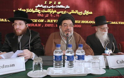 Le dignitaire religieux Ali Akbar Mohtashamipour, au centre, parle lors d'une conférence sur le négationnisme avec le rabbin Moishe Arye Friedman, à gauche, d'Autriche, et le rabbin Ahron Cohen, à droite, d'Angleterre, à Téhéran, en Iran, le 11 décembre 2006. (Crédit : AP/Vahid Salemi)