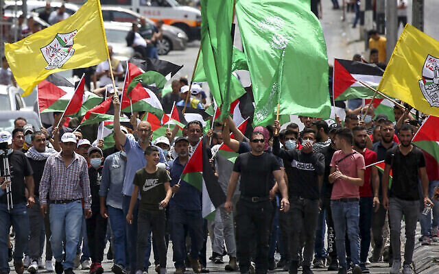 Des Palestiniens marchent dans la ville de Bethléem en Cisjordanie avec les drapeaux palestiniens, du Hamas et du Fatah, le 21 mai 2021. (Crédit : Wissam Hashlamoun/Flash90)