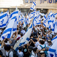 Des Israéliens agitent des drapeaux israéliens et dansent pendant la Marche des Drapeaux près de la Vieille Ville de Jérusalem, le 15 juin 2021. (Crédit :  Yonatan Sindel / Flash90)