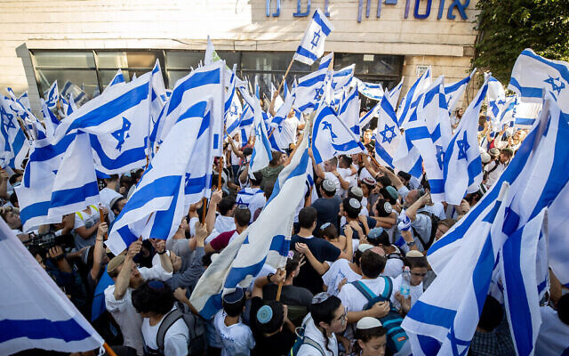 Des Israéliens agitent des drapeaux israéliens et dansent pendant la Marche des Drapeaux près de la Vieille Ville de Jérusalem, le 15 juin 2021. (Crédit :  Yonatan Sindel / Flash90)