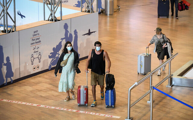 Des voyageurs arrivent à l'aéroport international Ben Gourion, le 23 juin 2021. (Crédit : Flash90)