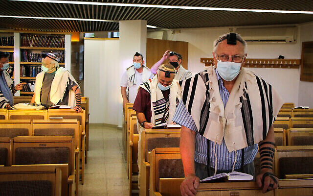 Des hommes portant des masques de protection dans une synagogue de l'implantation juive d'Efrat, le 27 juin 2021. (Crédit : Gershon Elinson/Flash90)