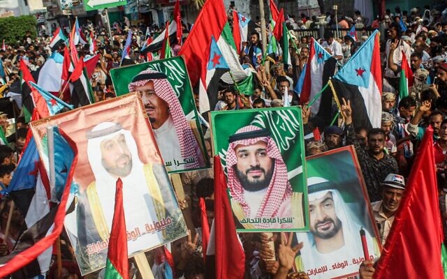 Des gens défilent avec des drapeaux du sud-Yémen, des EAU et de l'Arabie saoudite ainsi que des portraits du roi saoudien  Salman bin Abdulaziz, au centre-gauche, du prince Prince Mohammed bin Salman, au centre à droite, du président des EAU Khalifa bin Zayed al-Nahyan (à gauche) et de son frère, le prince héritier d'Abu Dhabi Mohammed bin Zayed al-Nahyan (à droite) pensant un défilé à Aden, la seconde ville la plus grande du Yémen, le 5 septembre 2019. (Crédit : Saleh Al-OBEIDI/AFP)