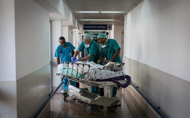 Illustration : Des médecins et des infirmières traitent un patient à l'hôpital Wolfson à Holon. (Crédit : Hadas Parush/Flash90)