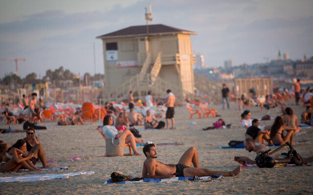 Les Israéliens profitent de la plage à Tel Aviv au cours d'une chaude journée estivale, le 6 juillet 2021. (Crédit : Miriam Alster/Flash90)