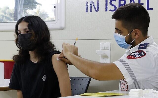 Une jeune Israélienne reçoit une dose du vaccinPfizer/BioNTech COVID-19 lors d'une campagne de la municipalité de Tel Aviv-Yafo pour encourager la vaccination des adolescents, le 5 juillet 2021, à Tel Aviv (Crédit : JACK GUEZ / AFP)