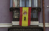 Illustration : Un drapeau espagnol sur un rebord de fenêtre avec un ruban noir à Madrid, le 12 avril 2020. (Crédit: AP Photo/Bernat Armangue)