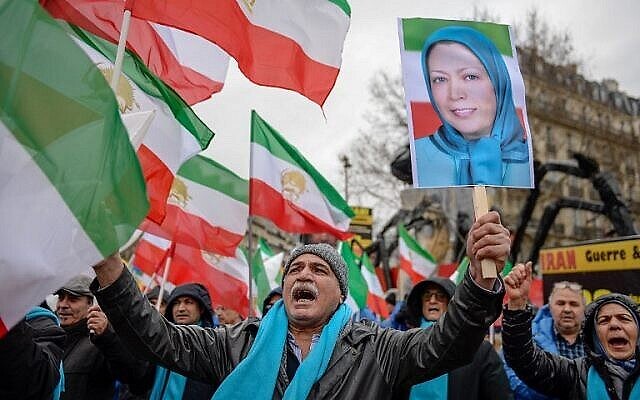 Des gens brandissent d'anciens drapeaux iraniens et une photo de Maryam Radjavi, chef des Moudjahidine du peuple d'Iran, lors d'une manifestation de l'opposition iranienne en exil pour protester contre le gouvernement iranien, le 8 février 2019 à Paris. (AFP)