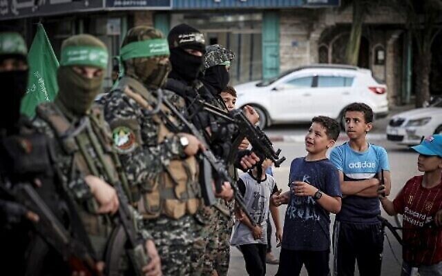 Des jeunes Palestiniens attendent de pouvoir s'inscrire à un camp d'été organisé par l'aile militaire du Hamas, les Brigades  Iz-Ad Din Al-Qassam à Gaza City, le 14 juin 2021. (Crédit : Mahmud Hams/AFP)
