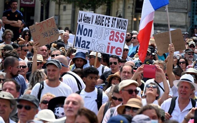 Un manifestant tient une pancarte indiquant "non au pass nazitaire" lors d'une manifestation de protestation contre la vaccination obligatoire Covid-19 pour certains travailleurs et l'utilisation obligatoire du pass sanitaire réclamée par le gouvernement français à Montpellier, le 31 juillet 2021. (Crédit : 
 Pascal GUYOT / AFP)