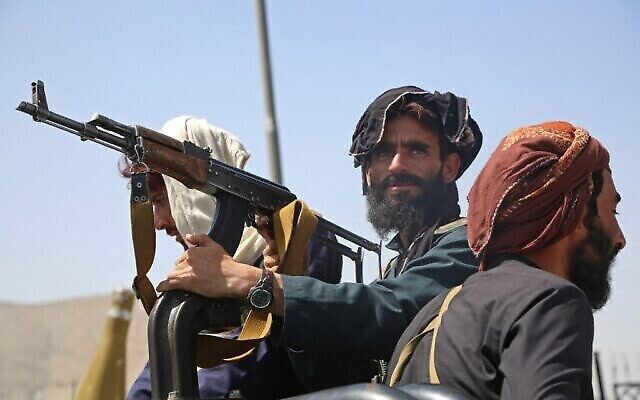 Des combattants talibans montent la garde dans un véhicule au bord de la route à Kaboul, le 16 août 2021. (AFP)