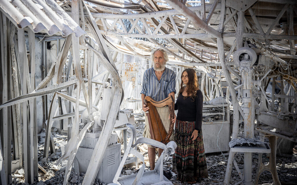 Shoshanna et Micah Harari dans les ruines de leur fabrique de harpe au moshav Ramat Raziel, sur les collines de Jérusalem, après un incendie de forêt, le 18 août 2021. (Crédit : Yonatan Sindel/Flash90)