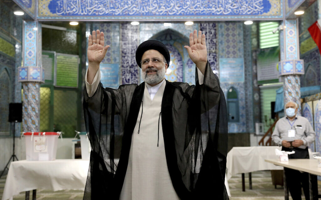 Ebrahim Raïssi, candidat aux élections présidentielles iraniennes, salue les médias après avoir voté dans un bureau de vote à Téhéran, en Iran, le vendredi 18 juin 2021. (Crédit : AP Photo/Ebrahim Noroozi)