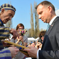 Edward Mossberg, survivant de la Shoah, rencontre le président polonais  Andrzej Duda, lors d'une cérémonie de la Marche des Vivants dans le camp d'extermination d'Auschwitz-Birkenau en Pologne, alors qu'Israël célèbre Yom HaShoah, le 12 avril 2018. (Crédit : Yossi Zeliger/ Flash90/ File)